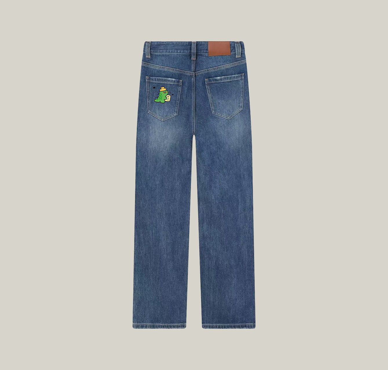 A pair of jeans featuring a print of a little dinosaur wearing a hat—a wardrobe essential.