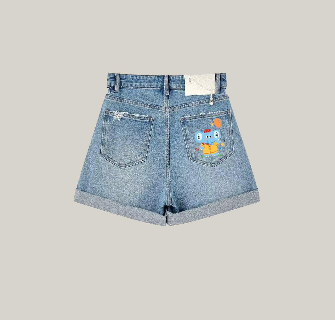 A pair of denim shorts featuring a little elephant print—an essential item for your summer wardrobe.