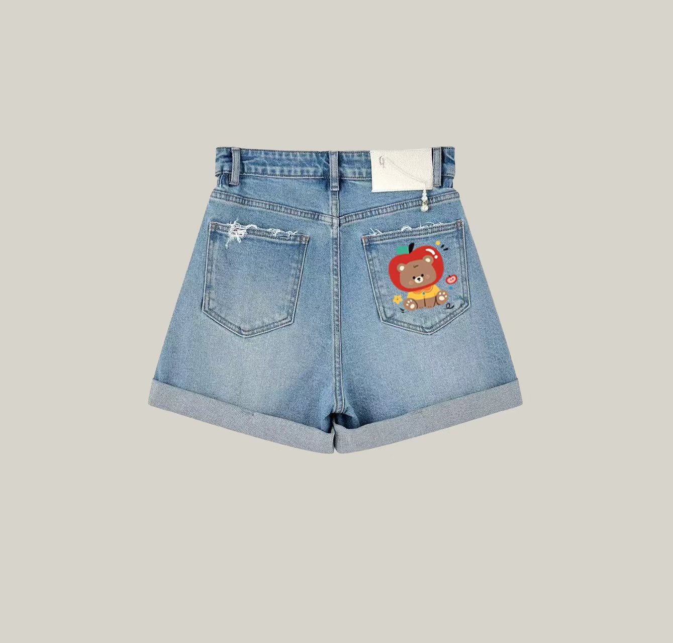 A pair of denim shorts featuring a teddy bear print—an essential item for your summer wardrobe.