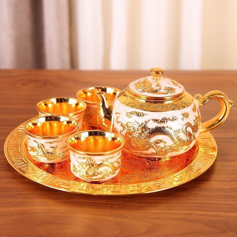 A six-piece set of gilded tea sets in gold and off-white color