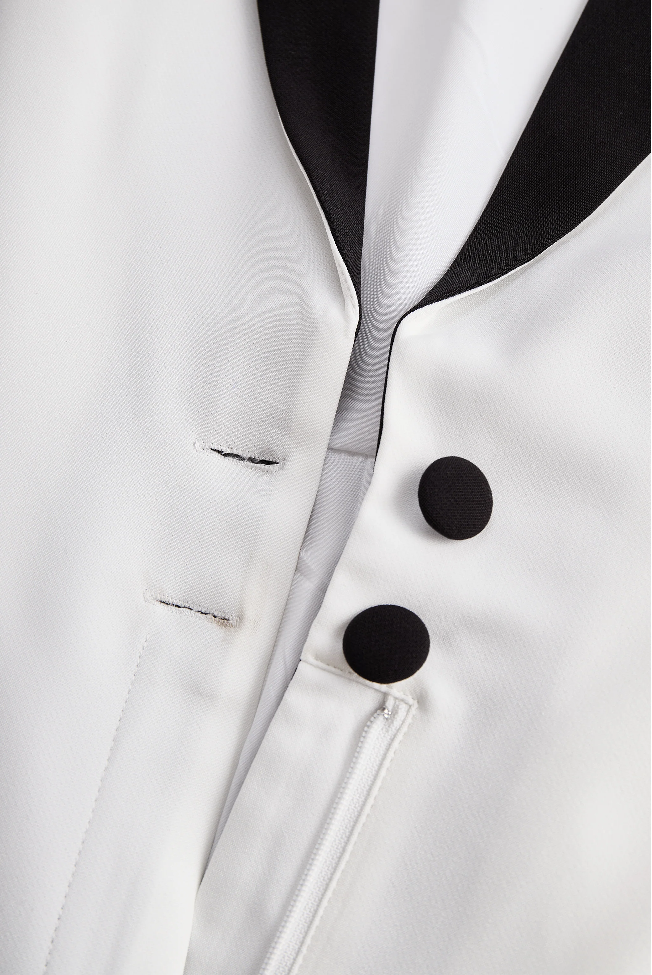 Sleek White Jumpsuit With Dual Button Detail And Black Lapel