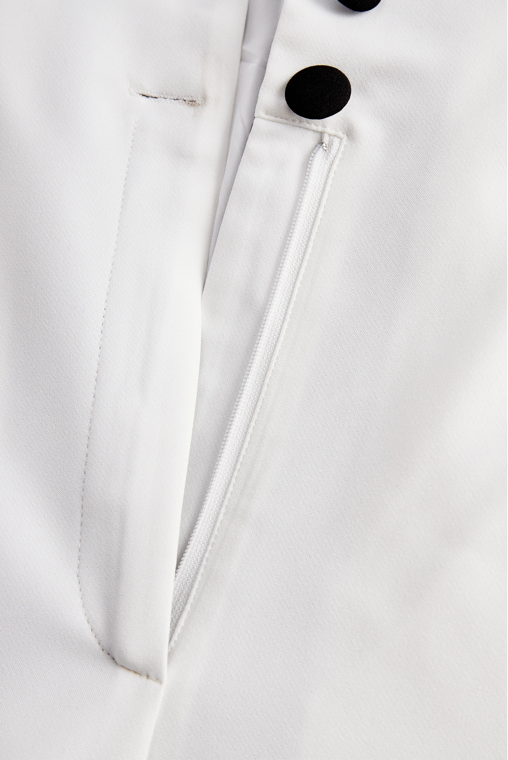 Sleek White Jumpsuit With Dual Button Detail And Black Lapel